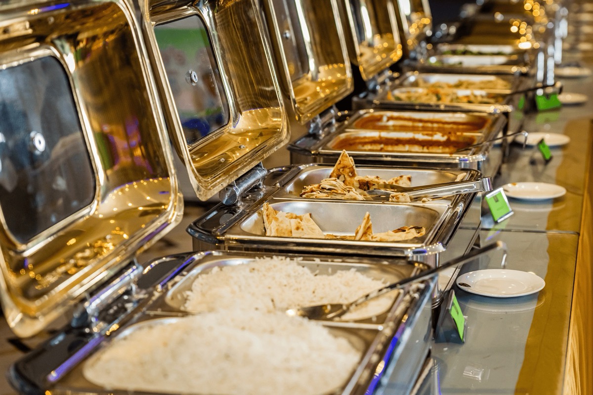 A catering buffet spread of curries and rice prepared for a religious event