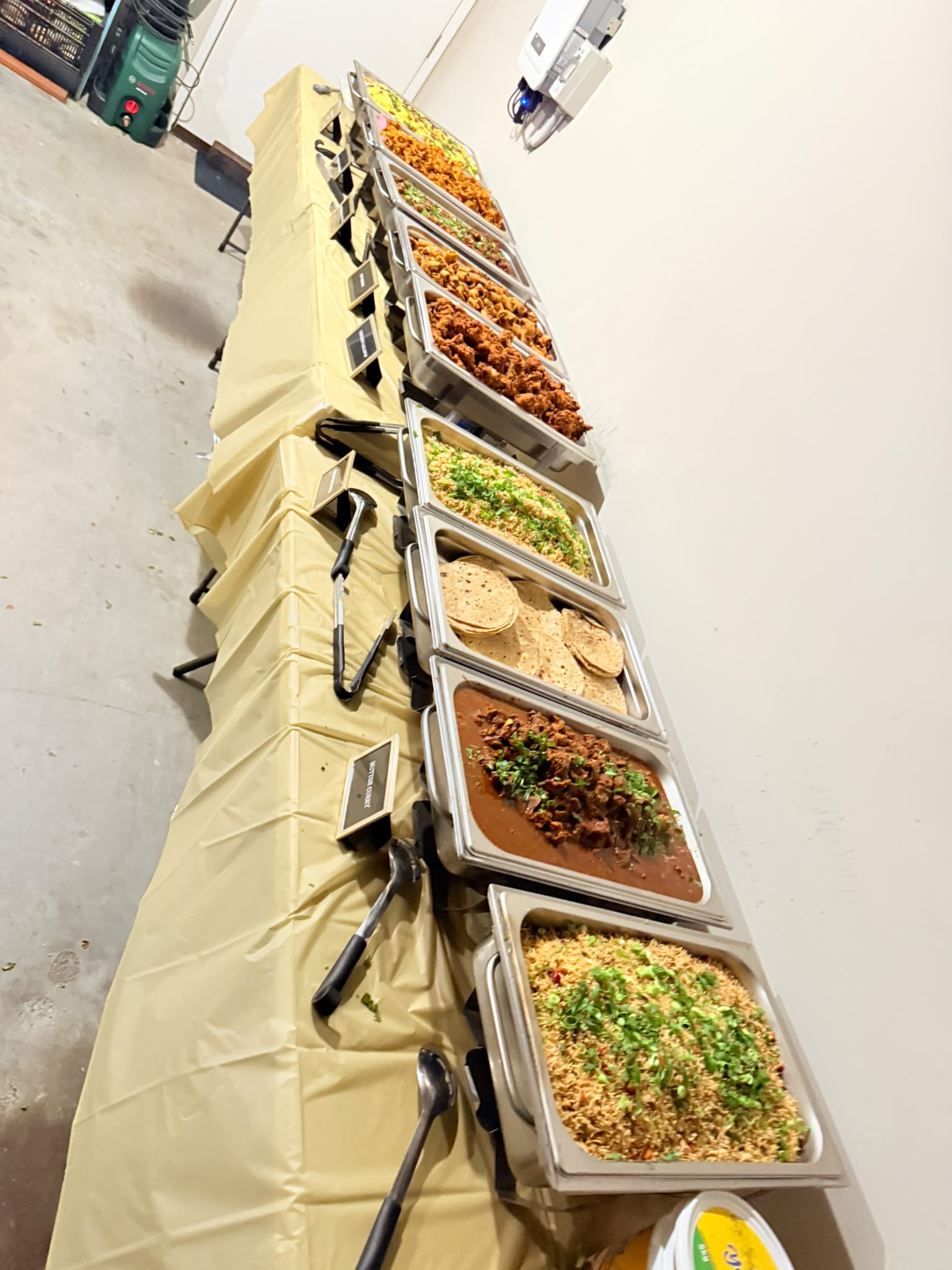 A long buffet table of chafing dishes set up for a private gathering