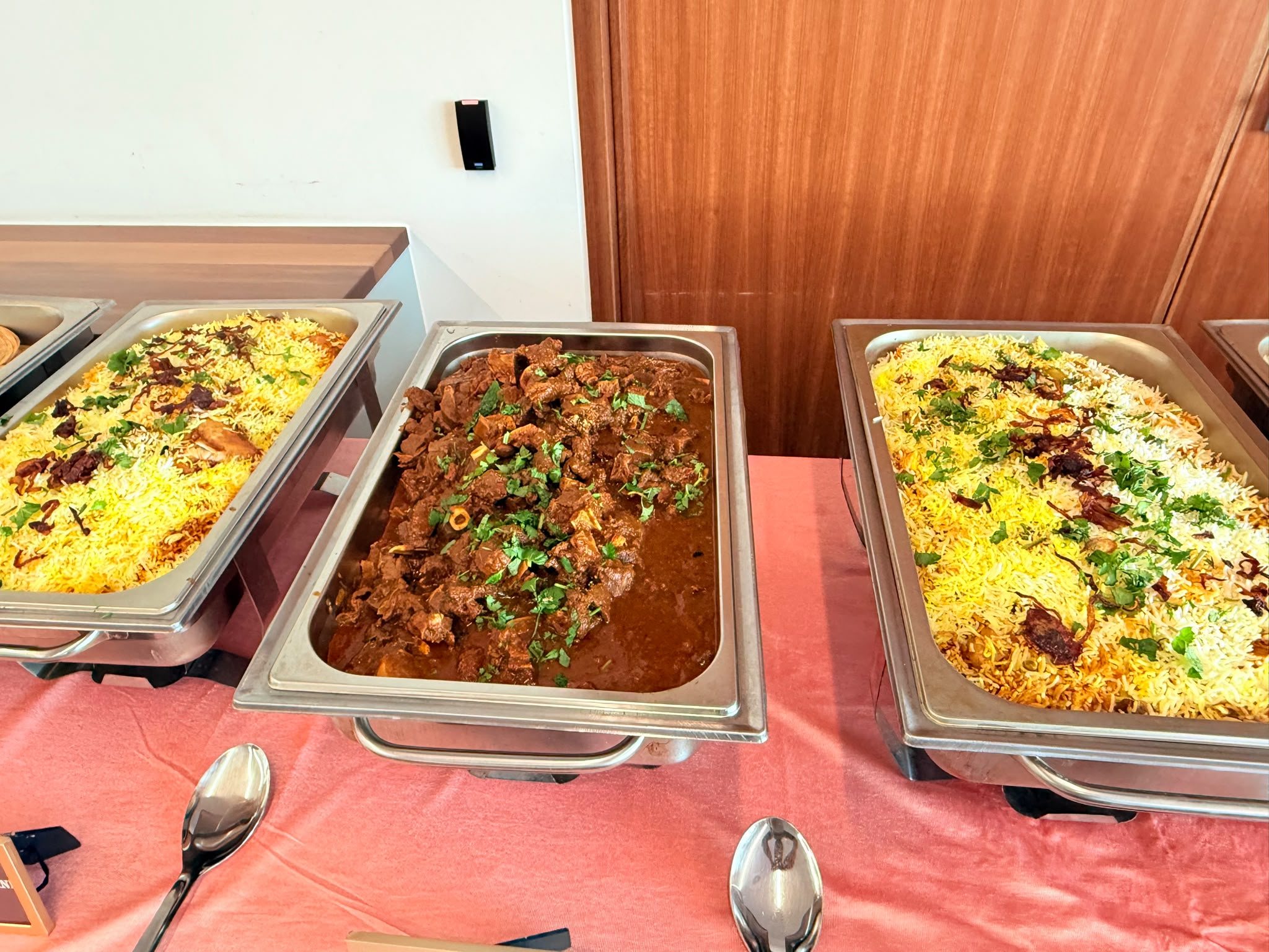 Trays of biryani and mutton curry set out for a private party